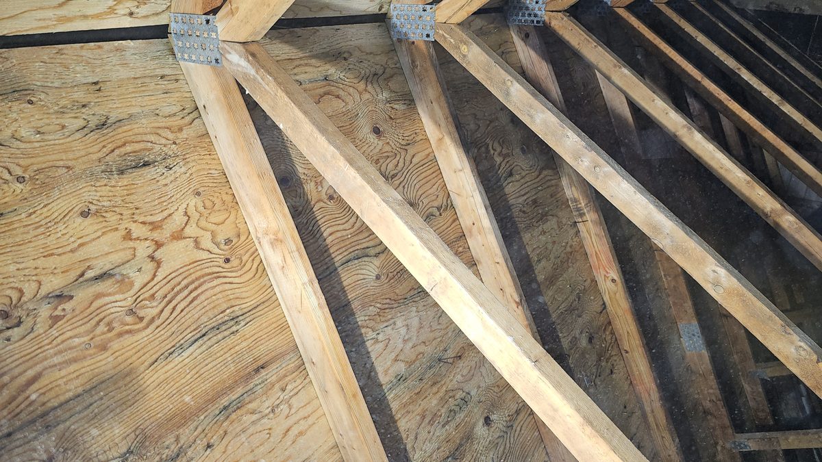 Clean natural wood grain on attic sheathing after mold removal treatment